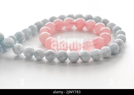 Rose quartz bracelet and aquamarine strand on the table. Stock Photo