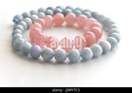Rose quartz bracelet and aquamarine strand on the table. Stock Photo