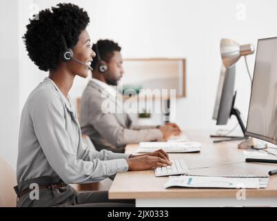 Call center worker talking on online communication with computer in office, giving advice at telemarketing company and consulting on internet. Happy Stock Photo