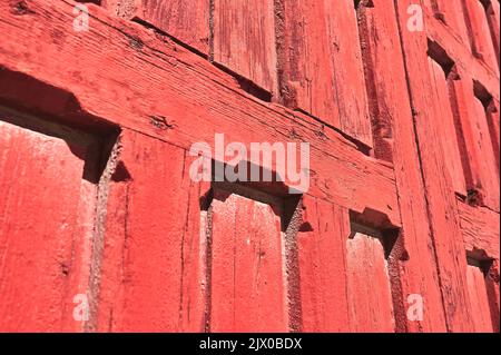 detail of a very deteriorated red wooden door Stock Photo