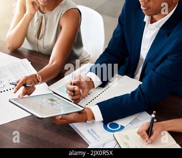 Business manager, ceo or leader holding digital tablet presenting financial data to colleagues in meeting. Brainstorming and planning ideas with Stock Photo