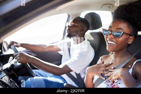 African couple driving in car on holiday, smile for travel on vacation in summer and conversation on road trip journey together. Happy man and woman Stock Photo