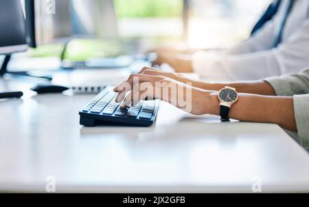 Hands, keyboard and typing with a business woman working on a computer at her desk in the office. Fingers, email and report with a female employee at Stock Photo
