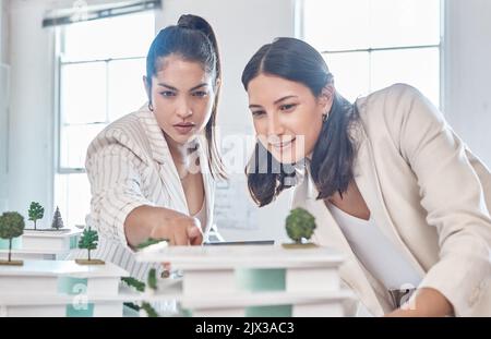Architect, team and engineer meeting while women discuss 3d architectural model vision. Teamwork and collaboration while talking and planning Stock Photo