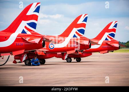 Member of the Royal Air Force aerobatic team, known as the Red Arrows, working on a laptop at RAF Fairford, England. The Red Arrows pilot the BAE Systems Hawk T1 aircraft, a two seater plane used for pilot training. The Hawk T1 can reach a top speed of 1037 km/h. It is powered by a single Rolls-Royce Turbomeca Adour Mk 861 turbofan. Photographed on the 2nd of June 2022. Stock Photo