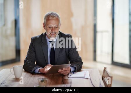 Tracking his companys growth. a businessman using a digital tablet. Stock Photo