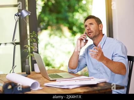 Let me get this right...a young man working from home. Stock Photo