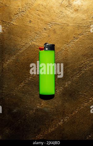Neon lime green safety lighter on gold background Stock Photo