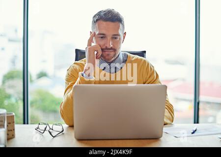 A businessman working on his laptop at his desk. Stock Photo