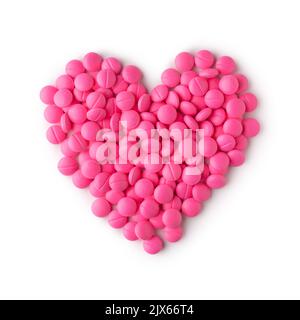 pink round pills or tablets arranged in heart shape, medical drugs taken straight from above isolated on white background Stock Photo