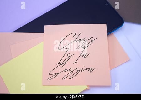 Class Is In Session. Text on adhesive note paper. Event, celebration reminder message. Stock Photo