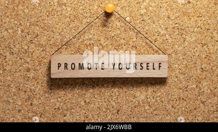 word promote yourself written on wooden surface. Hanging on wooden board. work and education Stock Photo