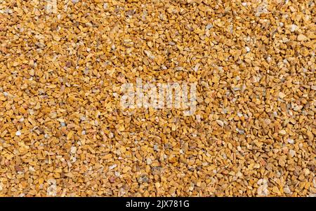 lose up of small stone texture. Abstract background of decorative floor, pebble stones. Gravel, yellow-orange road in the park. Stock Photo