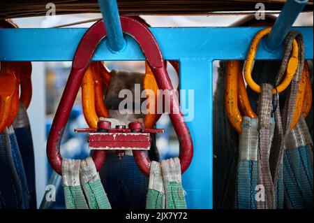 Rigging equipment with strops hangs on rack in warehouse Stock Photo ...