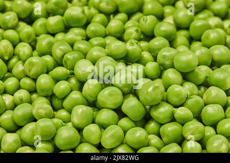 Background Fresh green peas heap on wooden texture background Stock Photo