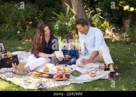 Premium Photo | Mom and daughter on a picnic by the lake eat and watch  cartoons on the phone