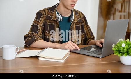 cropped shot, A smart young Asian man programmer or tech engineer working at his office desk, using laptop computer. Stock Photo