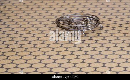 Metal trivets stacked on a dining table. Stock Photo