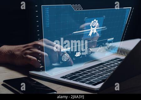 Standards and quality in business and product manufacturing. The person is working on a laptop. Stock Photo