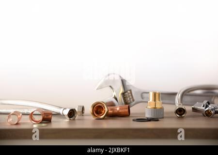 Plumbing conceptual background with tools and metal pipes on white background. Front view. Horizontal composition. Stock Photo