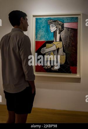 'Man looking at Portrait of Jacqueline Roque with her hands crossed' created in 1954 by Pablo Picasso in Cubism style,. Picasso Museum, an art gallery Stock Photo