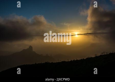 Thin clouds cover the sun before sunset in a dramatic landscape in Gran Canaria island center, view from Cruz de Tejeda Stock Photo
