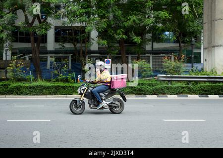 Lumphini, THAILAND - August 26, 2022 : Motorcycle deliveries running fast on the road area lumphini in Bangkok, Thailand. Stock Photo