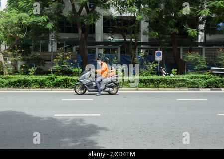 Lumphini, THAILAND - August 26, 2022 : Motorcycle deliveries running fast on the road area lumphini in Bangkok, Thailand. Stock Photo