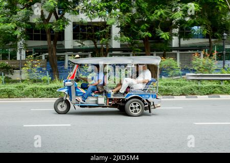 Lumphini, THAILAND - August 26, 2022 : Tricycle (tuk-tuk) running fast on the road area lumphini in Bangkok, Thailand. Stock Photo