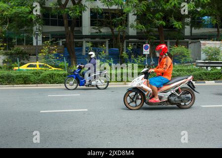 Lumphini, THAILAND - August 26, 2022 : Motorcycle deliveries running fast on the road area lumphini in Bangkok, Thailand. Stock Photo