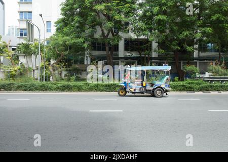 Lumphini, THAILAND - August 26, 2022 : Tricycle (tuk-tuk) running fast on the road area lumphini in Bangkok, Thailand. Stock Photo