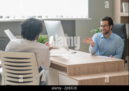 Work on project. Two businessmen looking busy while discussing project in the office Stock Photo