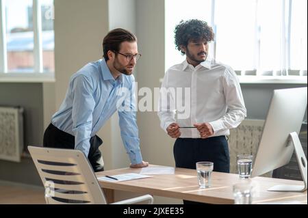 Work on project. Two businessmen looking busy while discussing project in the office Stock Photo