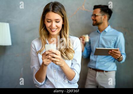 Diverse business people colleagues laughing having fun with digital gadgets in office. Stock Photo