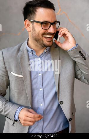 Portrait of young successful businessman with digital device working in corporate business office Stock Photo