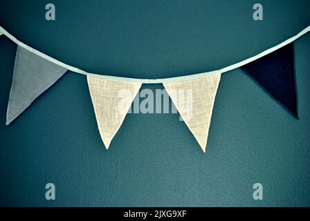 close-up of four pennants in front of turquoise blue green background Stock Photo
