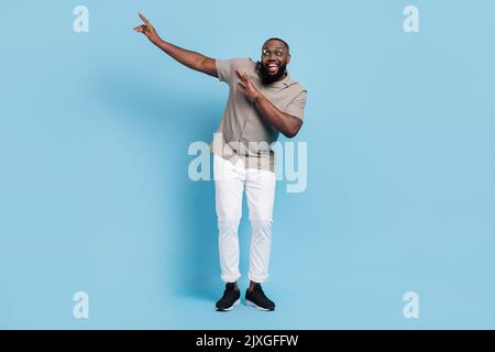Full size photo of overjoyed cheerful man enjoy free time dancing partying isolated on blue color background Stock Photo