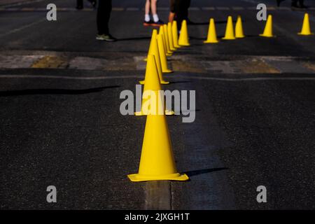 yellow traffic cones on dark asphalt indicating turn Stock Photo