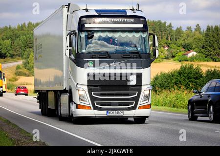 White Volvo FH truck Globetrotter cab pulls semi trailer in highway traffic on a day of late summer. Salo, Finland. August 25, 2022. Stock Photo