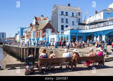 Bridlington old town marina and Bridlington Harbour at low tide with tourists sat enjoying the sunshine East Riding of Yorkshire England UK GB Europe Stock Photo