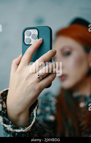 Attractive woman posing takes selfie on iPhone 13 pro. Stock Photo