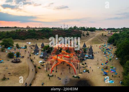 Dádpuszta, Hungary - 07 August, 2022 - Sunrise at the ozorian valley while peopla dancing at the main stage. O.Z.O.R.A. Festival. Stock Photo