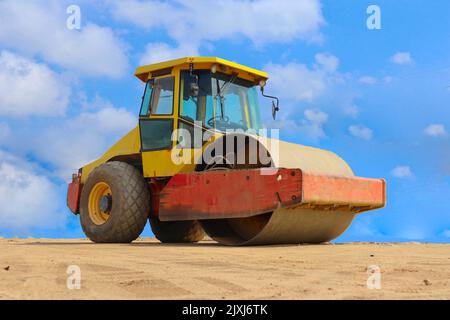 road roller with yellow color, on construction site and sky background Stock Photo