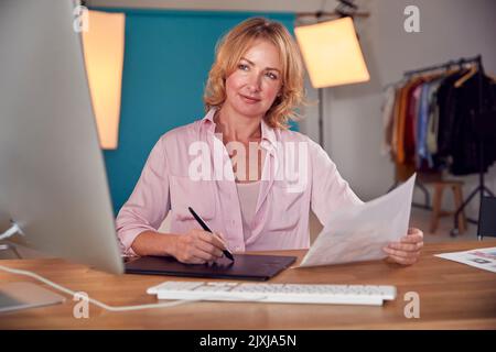Female Photographer Designer Or Retoucher At Desk Working On Images On Computer In Studio Stock Photo