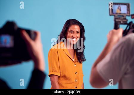 Mature Woman In Studio On Shoot With Video And Stills Camera Stock Photo
