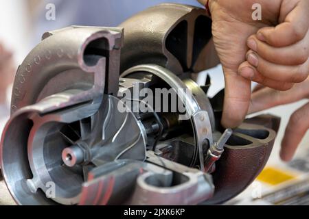 Truck turbo compressor cut. Inside of a car part. Human hand. Stock Photo