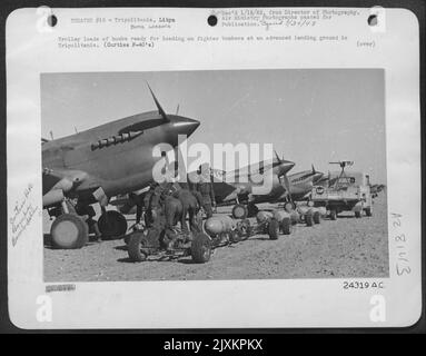 Trolley loads of bombs ready for loading on fighter bombers at an advanced landing ground in Tripolitania. (Curtiss P-40's). The activities of fighter bombers have been the principal feature of Allied air attacks in the present offensive in Libya. Stock Photo