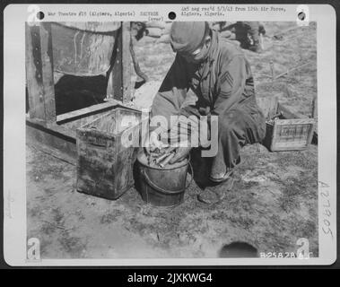 Algiers, Algeria-Salvage parts being washed after cleaning in reclamation drum used for cleaning and salvaging small parts such as nuts and bolts, washers, etc. April 1943. Stock Photo