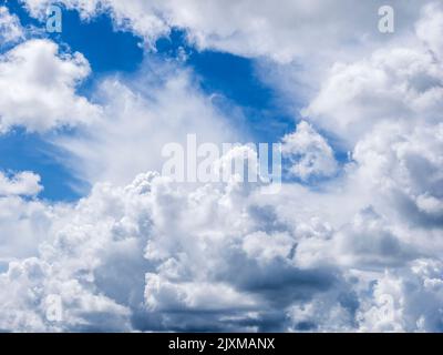Overhead white dramatic clouds in a blue sky Stock Photo