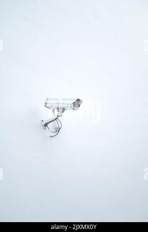CCTV security camera operating on a white wall with copy space  Stock Photo